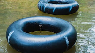 Old inner tubes floating on a river, selective focus