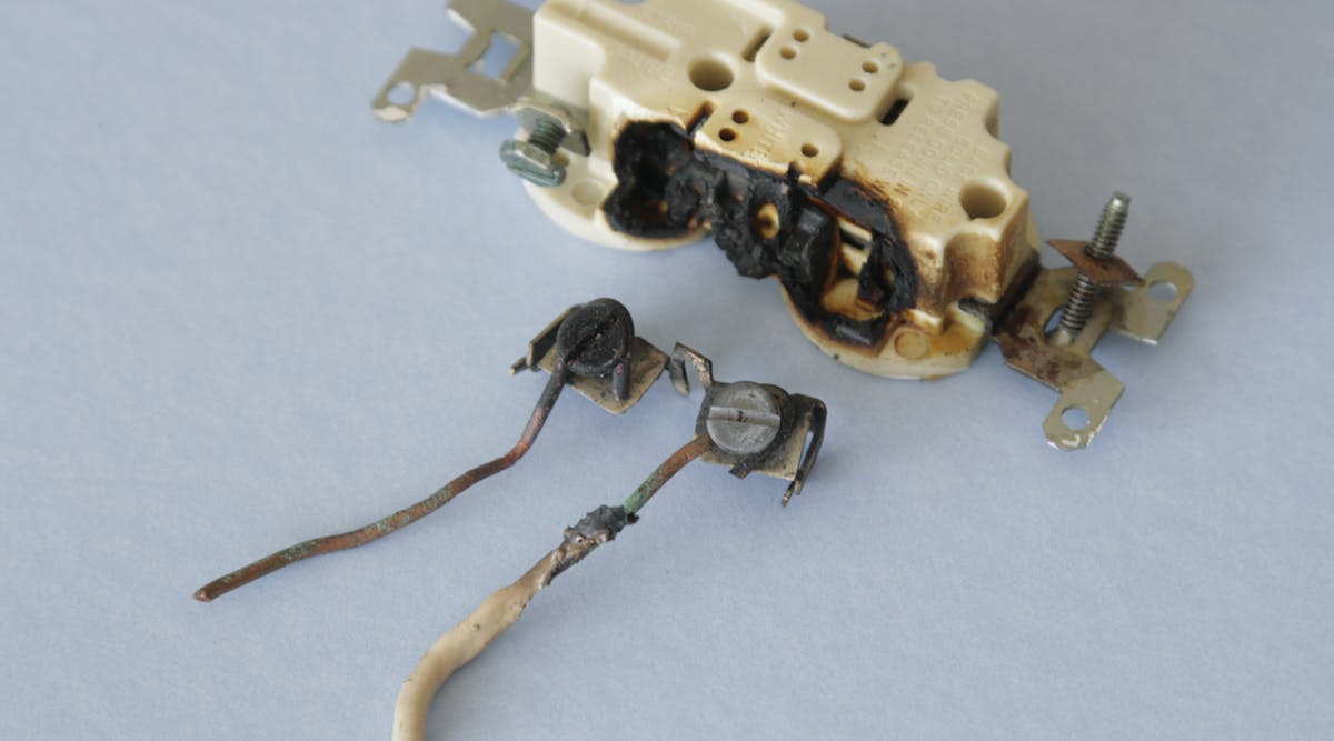 The damage resulting from a small arc flash involving a 120VAC duplex receptacle within a single gang box.