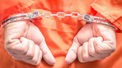 handcuffed hands orange jumpsuit