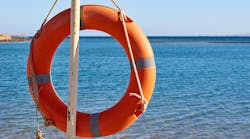 Emergency orange life buoy on sea beach