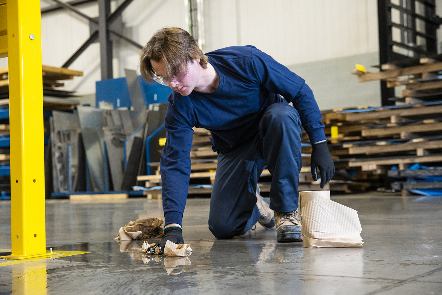 plant worker cleaning spill