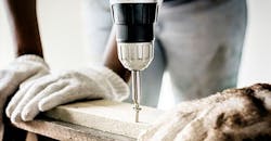 worker drilling screw into board worker drilling screw into board