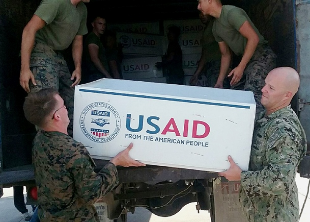 Petty Officer 1st Class Colby Wightman Right volunteered to assist in the humanitarian assistance and disaster relief efforts by loading and delivering 300 bags of beans and rice in two sorties to individuals affected by Hurricane Matthew in Jeremie