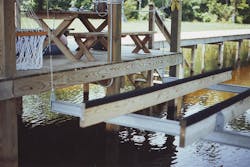 Photo 2. This image is of the boat lift assembly that was energized, with the metal rails visible, attached to the metal wires. Photo 2. This image is of the boat lift assembly that was energized, with the metal rails visible, attached to the metal wires.