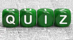 Quiz On Green Dice Sitting On Newspaper