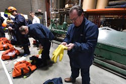 A group of Sturgeon Electric managers suit up in arc flash PPE as they take part in a session of the company's energized work training program. A group of Sturgeon Electric managers suit up in arc flash PPE as they take part in a session of the company's energized work training program.