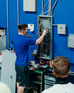 An instructor in a new fast-track apprenticeship program run by Independent Electrical Contractors of Central Indiana demonstrates voltage measurement to assembled students. An instructor in a new fast-track apprenticeship program run by Independent Electrical Contractors of Central Indiana demonstrates voltage measurement to assembled students.