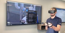 Josh Vollink, VDC designer, demonstrates how to use VR equipment in a simulated plant environment.