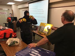 A Sturgeon Electric employee dons a balaclava as he prepares to work with an electrical panel mock-up in an energized work training session. A Sturgeon Electric employee dons a balaclava as he prepares to work with an electrical panel mock-up in an energized work training session.