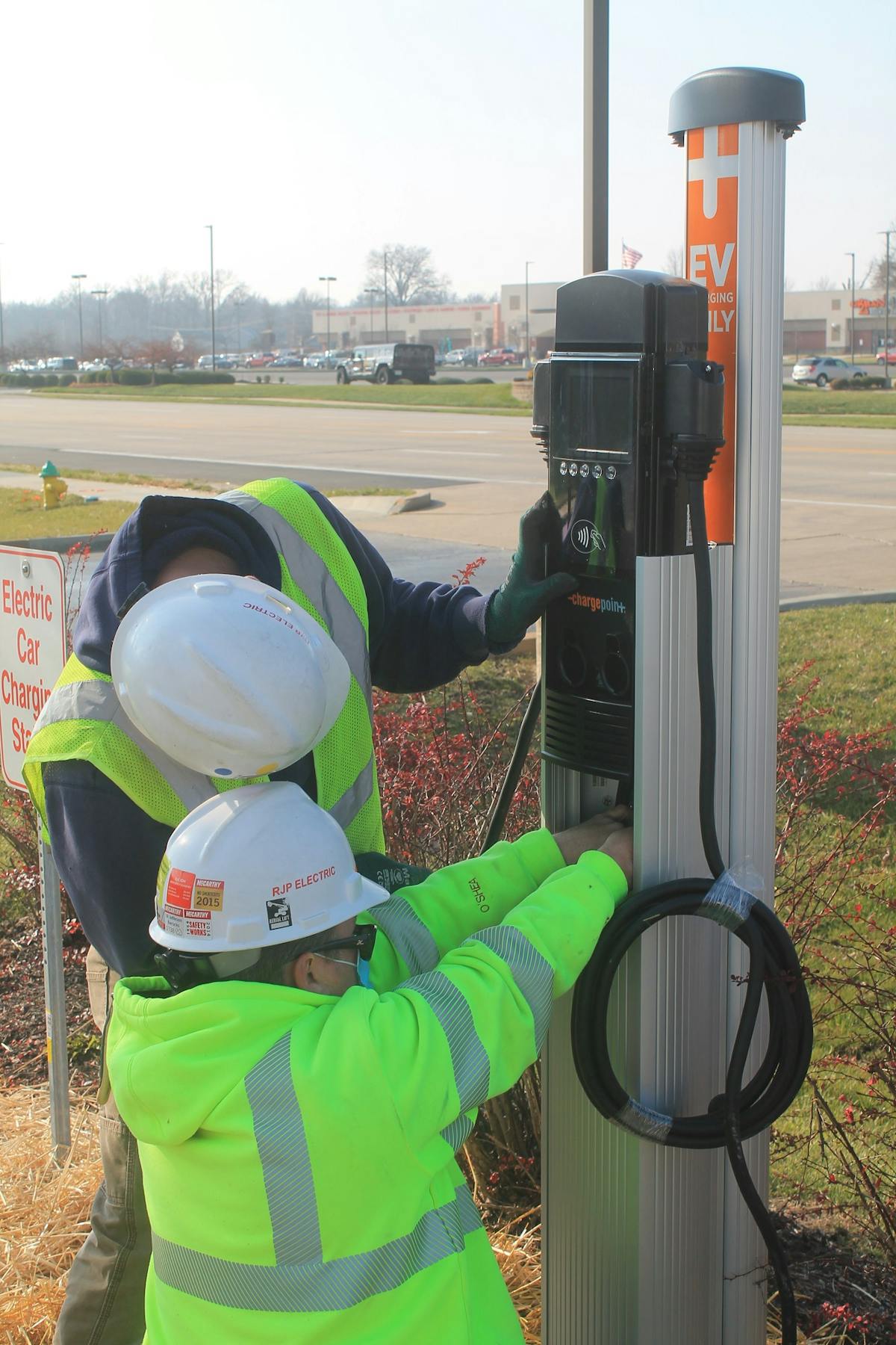 RJP Electric workers orient charging lines inside an EV charging station the company donated to St. Charles County (Mo.) Economic Development Center.