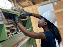 Azzure Ariel Addame, a TAIA School student, installs a three-phase 60A branch circuit to an industrial laminator in a commercial cabinetry manufacturing facility in Philadelphia. Azzure Ariel Addame, a TAIA School student, installs a three-phase 60A branch circuit to an industrial laminator in a commercial cabinetry manufacturing facility in Philadelphia.
