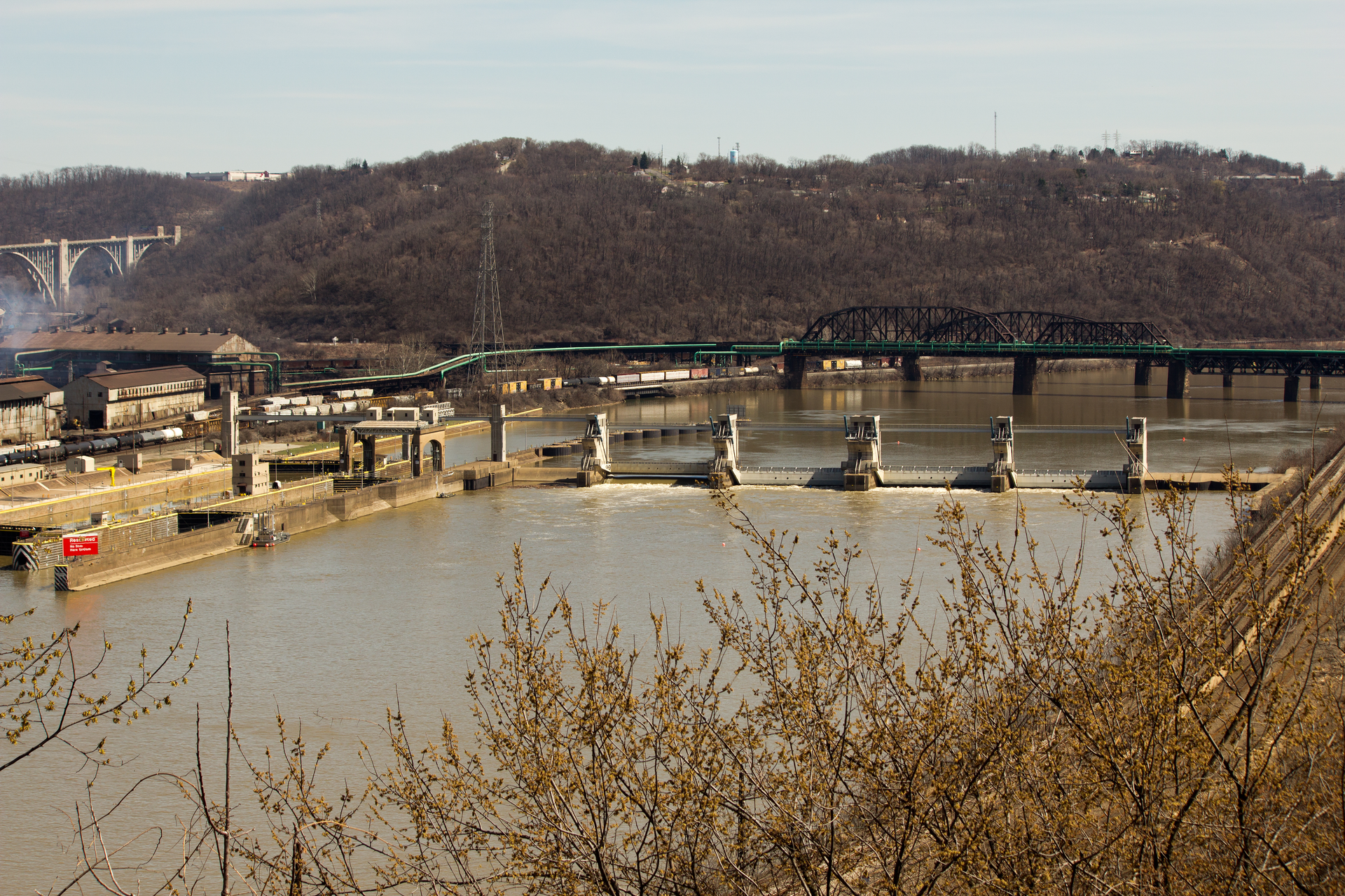 Distant view of a damn on the Monongahela River in Pittsburgh located next to a steel mill.