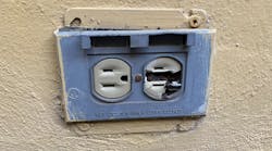 Damaged electrical outlet and receptacle on an outdoor wall