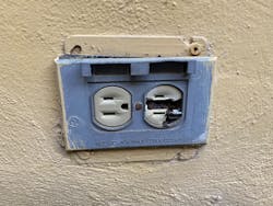 Damaged electrical outlet and receptacle on an outdoor wall Damaged electrical outlet and receptacle on an outdoor wall