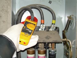 Photo 3. Practice extreme caution when using the clamp function of a multimeter inside of energized cabinets. Perform a visual inspection of conductors and the enclosure before placing the clamp around the conductor. Only one conductor (or phase conductor) can be inside the clamp at one time for accurate measurements.