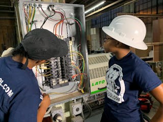 A licensed master electrician and electrical apprentice are working on a 3-phase commercial bolt-on panel and installing a 3-phase industrial edge bander at a woodworking shop in Philadelphia.