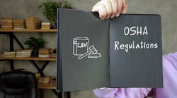 person holding open book with OSHA regulations text and law symbol