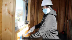 Dale Wolgamuth, who graduated in June 2022, is hammering in new work PVC boxes for receptacle and switch locations.