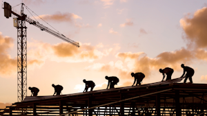 Construction Workers on Steel Structure with Crane in Background