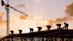 Construction Workers on Steel Structure with Crane in Background
