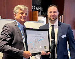 Randy Reid, executive director for the NLB (left), presents an NLB Citation Award to WAC Lighting's Daniel Moklas.