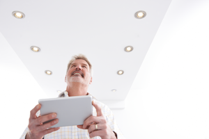 Man Controlling Lighting With App On Digital Tablet
