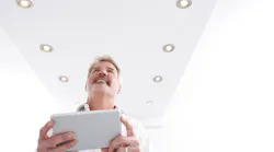 Man Controlling Lighting With App On Digital Tablet