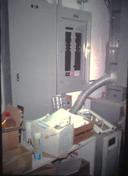 boxes and shelf piled up in front of electrical equipment
