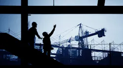 two people in silhouette at construction site