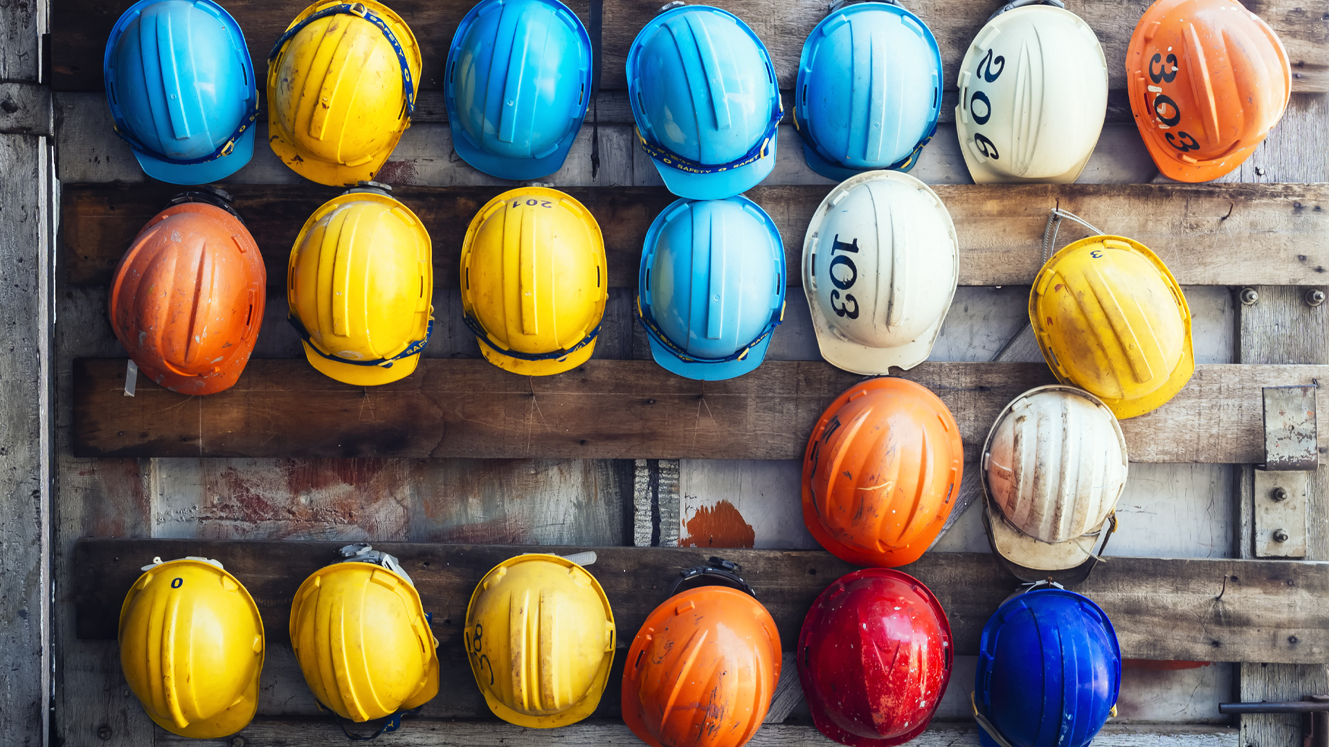 rows of construction hats hanging on a wall