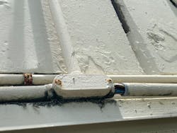 Poorly installed PVC conduit on side of building Poorly installed PVC conduit on side of building