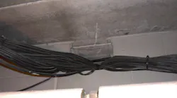 cables running through a cinder block wall