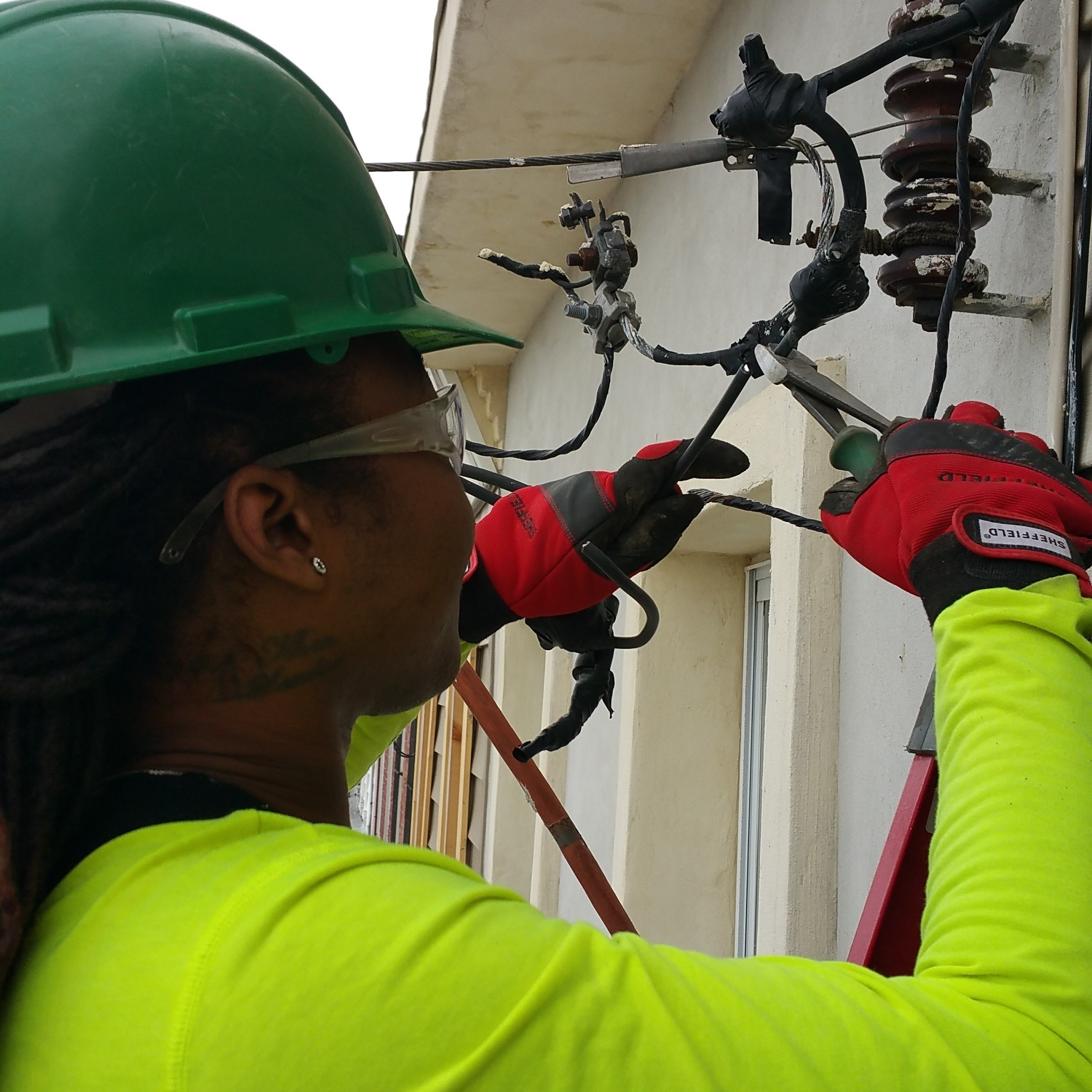 Monique Mobley, an electrical apprentice in Philadelphia, tying in a connection to the utility company. It's her first electrical service, 200 amps.