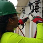 Monique Mobley, an electrical apprentice in Philadelphia, tying in a connection to the utility company. It&apos;s her first electrical service, 200 amps.