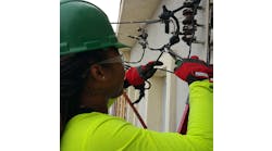 Monique Mobley, an electrical apprentice in Philadelphia, tying in a connection to the utility company. It&apos;s her first electrical service, 200 amps.