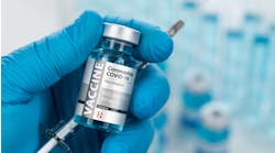 Surgical Glove Holding Coronavirus COVID-19 Vaccine Vial and Syringe Surgical Glove Holding Coronavirus COVID-19 Vaccine Vial and Syringe