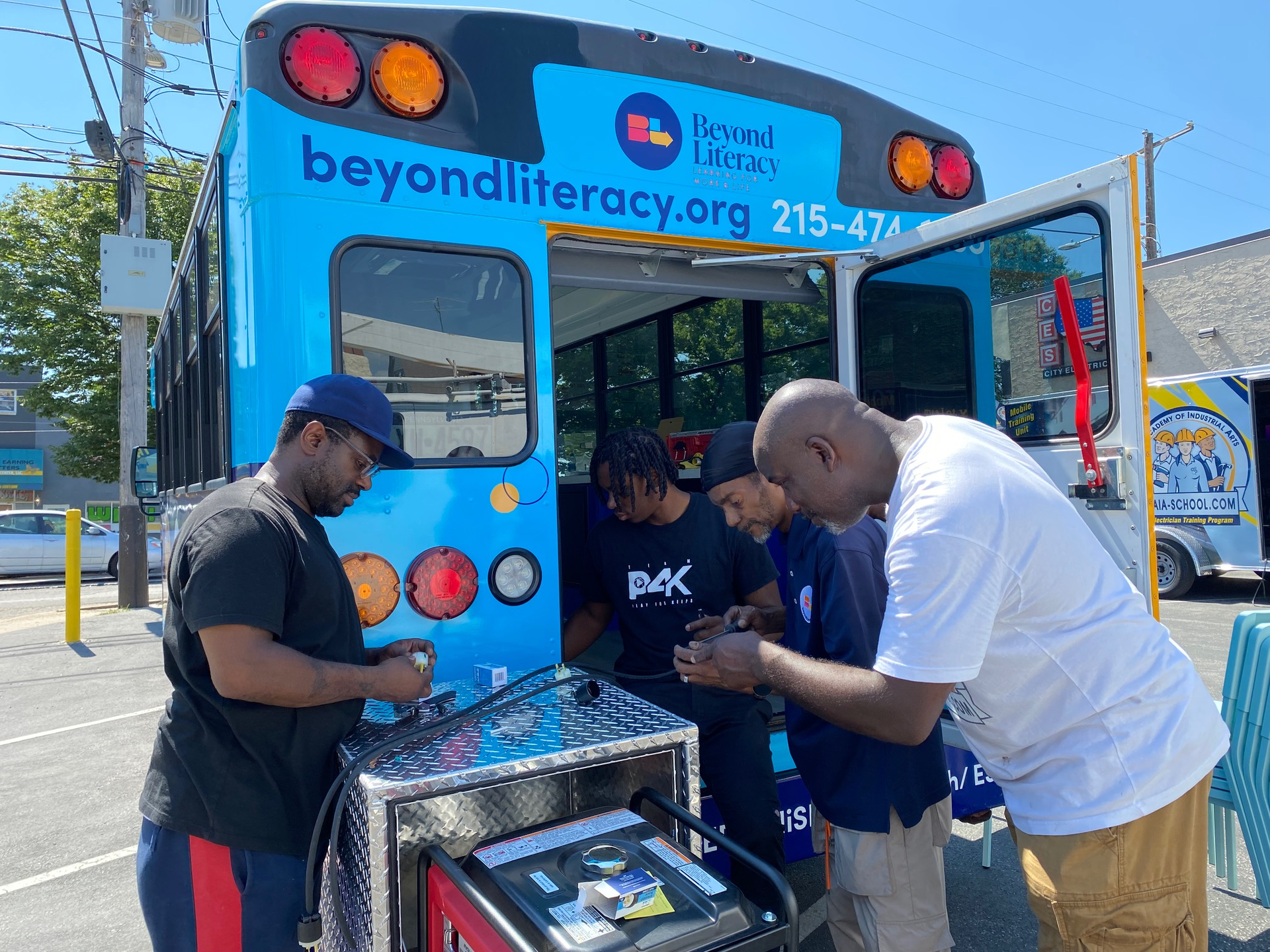 Working to wire the Beyond Literacy bus are (left to right): Attiim Roseborough; Zahir Rawls, The Academy of Industrial Arts (TAIA) student; Jemal Davis, BeLit IT tech and facilities coordinator, and Harold DeLoach, TAIA director of education and master electrician.