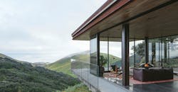 Photo 1. This structure in Central Coast, Calif. is powered by an array of 28 solar panels situated down the hill from the guesthouse to preserve views extending out into the ocean. The panels sit along the grade of the hill to maximize exposure to the sun. The conduit is run underground to the garage where the batteries and inverter live. Photo 1. This structure in Central Coast, Calif. is powered by an array of 28 solar panels situated down the hill from the guesthouse to preserve views extending out into the ocean. The panels sit along the grade of the hill to maximize exposure to the sun. The conduit is run underground to the garage where the batteries and inverter live.