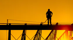 construction worker on site at sunset