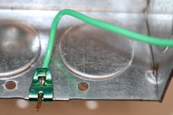 Photo 5. “Other Listed Means” include items such as ground clips used on metal boxes. They are listed for use on other than round boxes and for solid conductors only. The conductor is threaded through the clip, a screwdriver is used to push the clamp and conductor onto the edge of the box, and then the excess conductor is clipped off. Photo 5. “Other Listed Means” include items such as ground clips used on metal boxes. They are listed for use on other than round boxes and for solid conductors only. The conductor is threaded through the clip, a screwdriver is used to push the clamp and conductor onto the edge of the box, and then the excess conductor is clipped off.