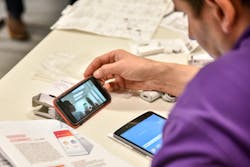 An installer reviews an online how-to video to aid a lighting installation. An installer reviews an online how-to video to aid a lighting installation.