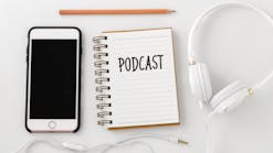 podcast written on notebook with phone and headphones