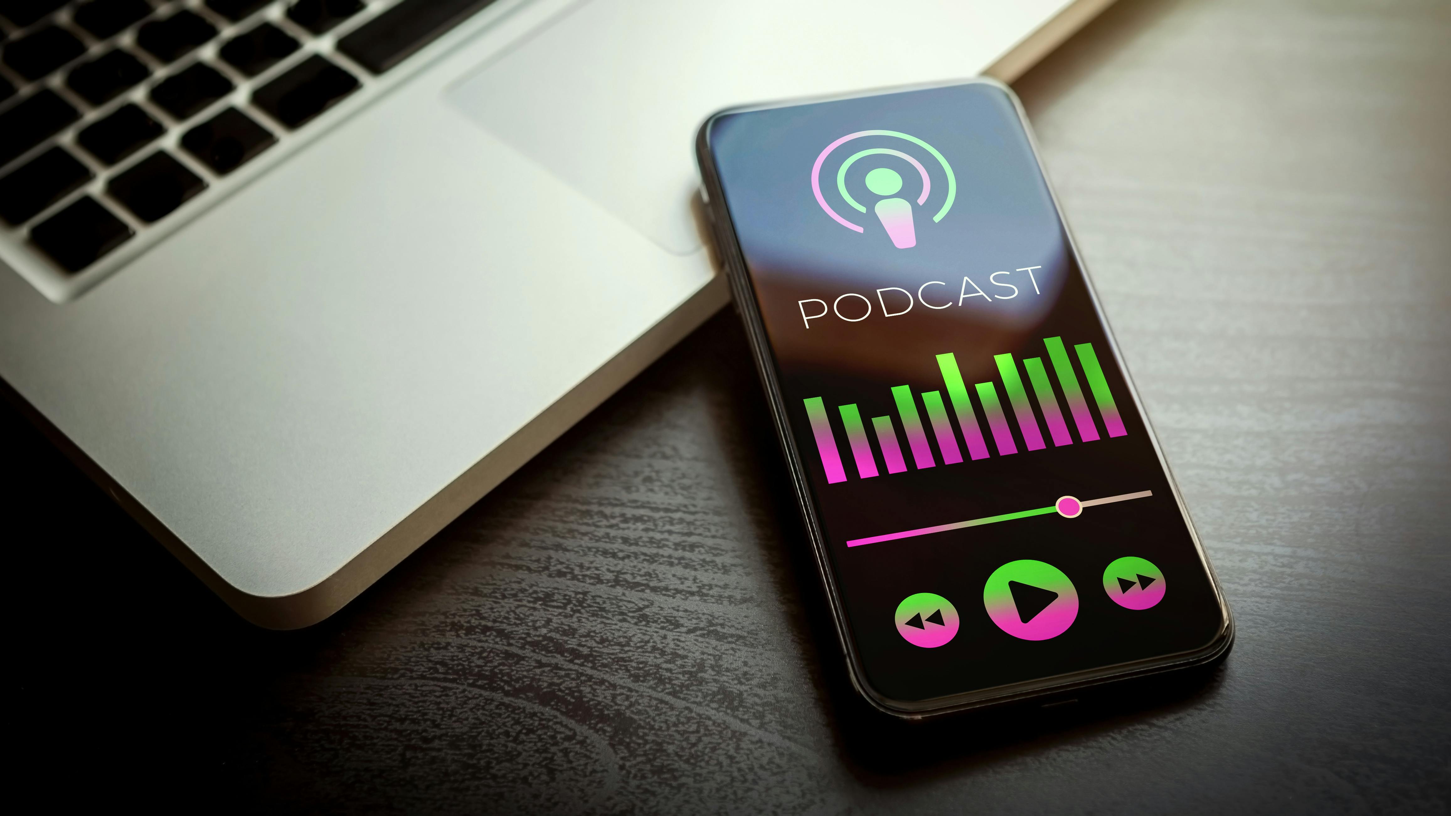 podcast on phone with laptop