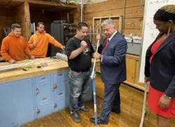 Photo 3. Building Trades Educational Benefit Fund instructor Axel Natal shows Gonzalez how to bend pipe with a conduit bender in front of a third-year apprentice class. Photo 3. Building Trades Educational Benefit Fund instructor Axel Natal shows Gonzalez how to bend pipe with a conduit bender in front of a third-year apprentice class.