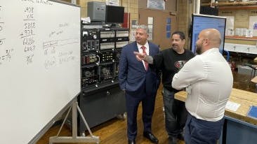 Building Trades Educational Benefit Fund instructor Axel Natal (center) shows Gonzalez calculations used by a class of third-year apprentices.