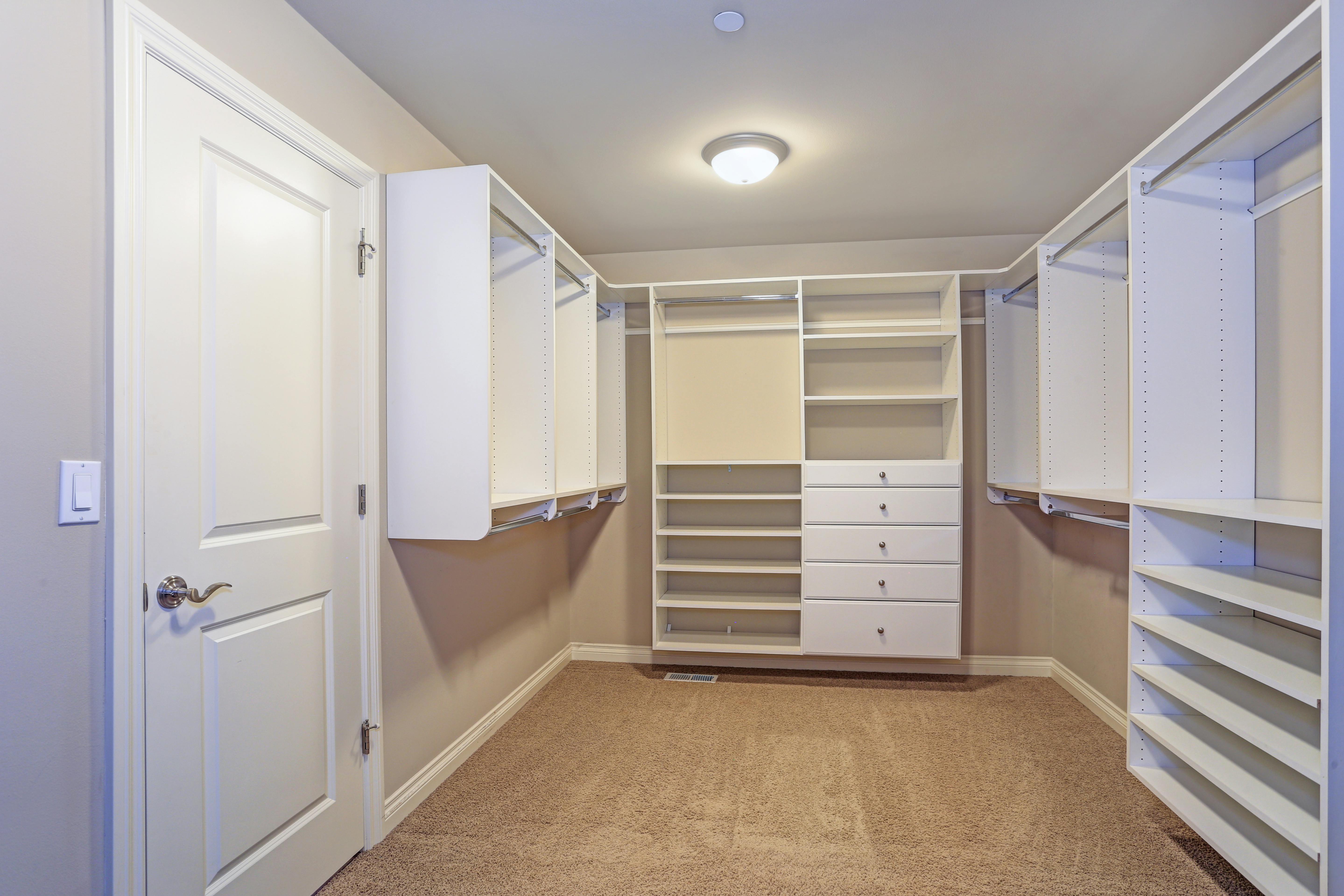 large walk-in closet with white shelves