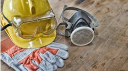 a yellow hard hat, respirator, safety goggles, and gloves on a wooden board a yellow hard hat, respirator, safety goggles, and gloves on a wooden board