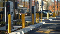 A row of electric vehicle chargers in front of an office building in a parking lot A row of electric vehicle chargers in front of an office building in a parking lot