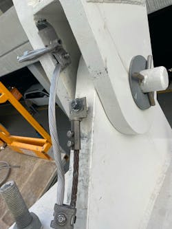 Photo 2. Added lightning bonding jumper to beam hinge to ensure lightning current flows across lowest impedance independent of hinge and pin. Photo 2. Added lightning bonding jumper to beam hinge to ensure lightning current flows across lowest impedance independent of hinge and pin.