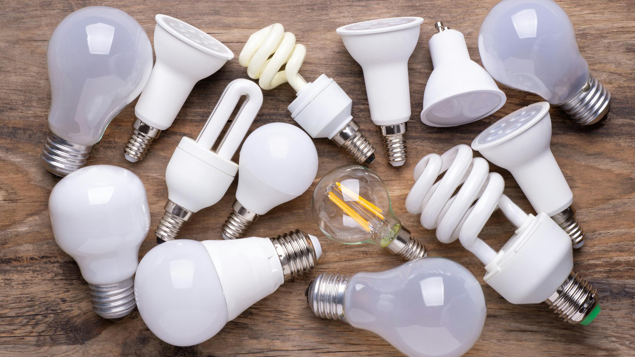 A variety of light bulbs against a wooden background